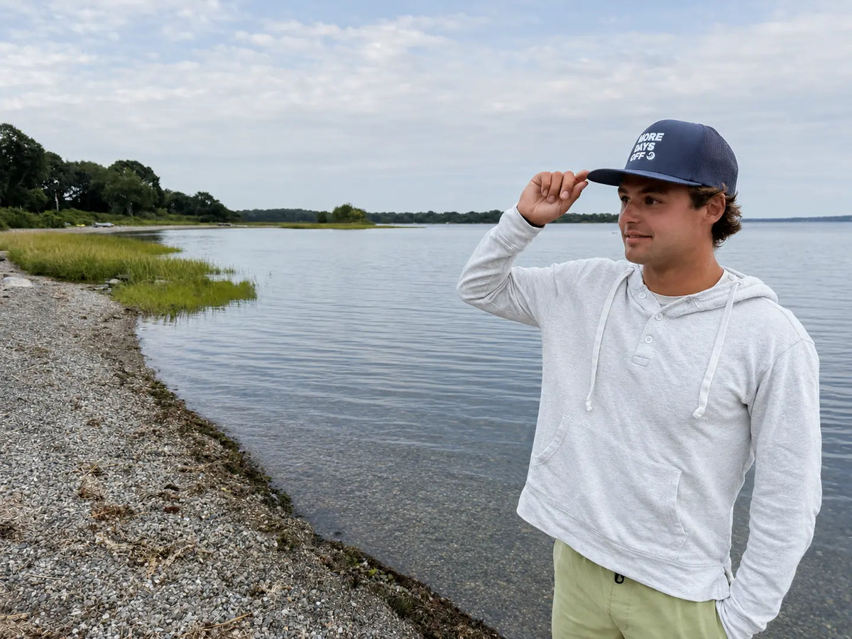 Coastal lifestyle view of the navy More Days Off hat