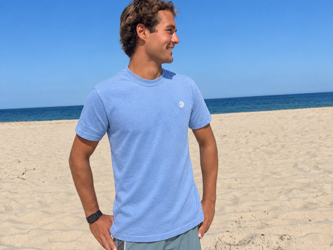 Model wearing the Blue Ocean Life Healing Wave embroidered denim tee on the beach