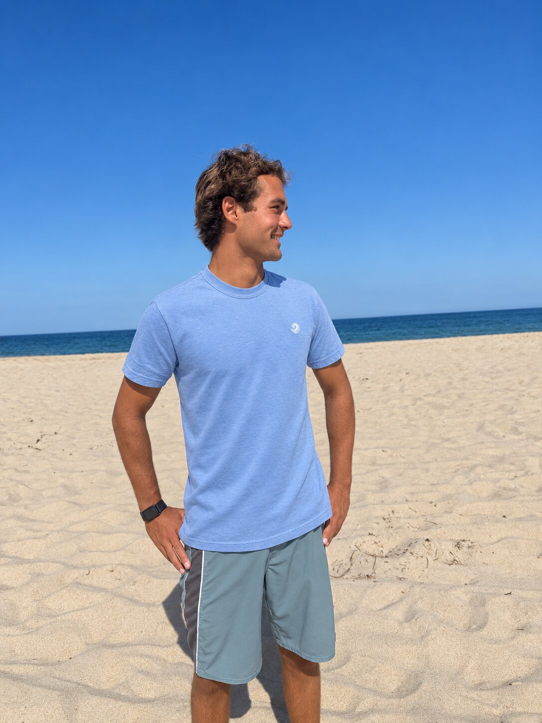 Model wearing the Blue Ocean Life Healing Wave embroidered denim tee on the beach