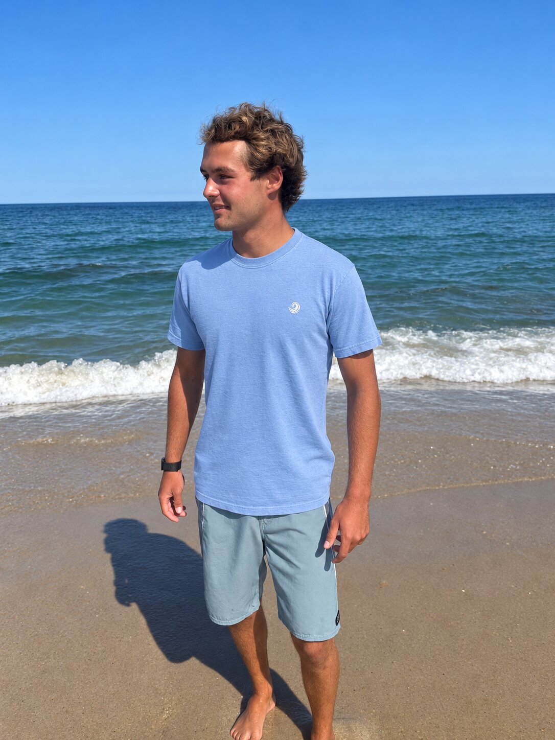 Model wearing the Healing Wave embroidered denim tee by the ocean
