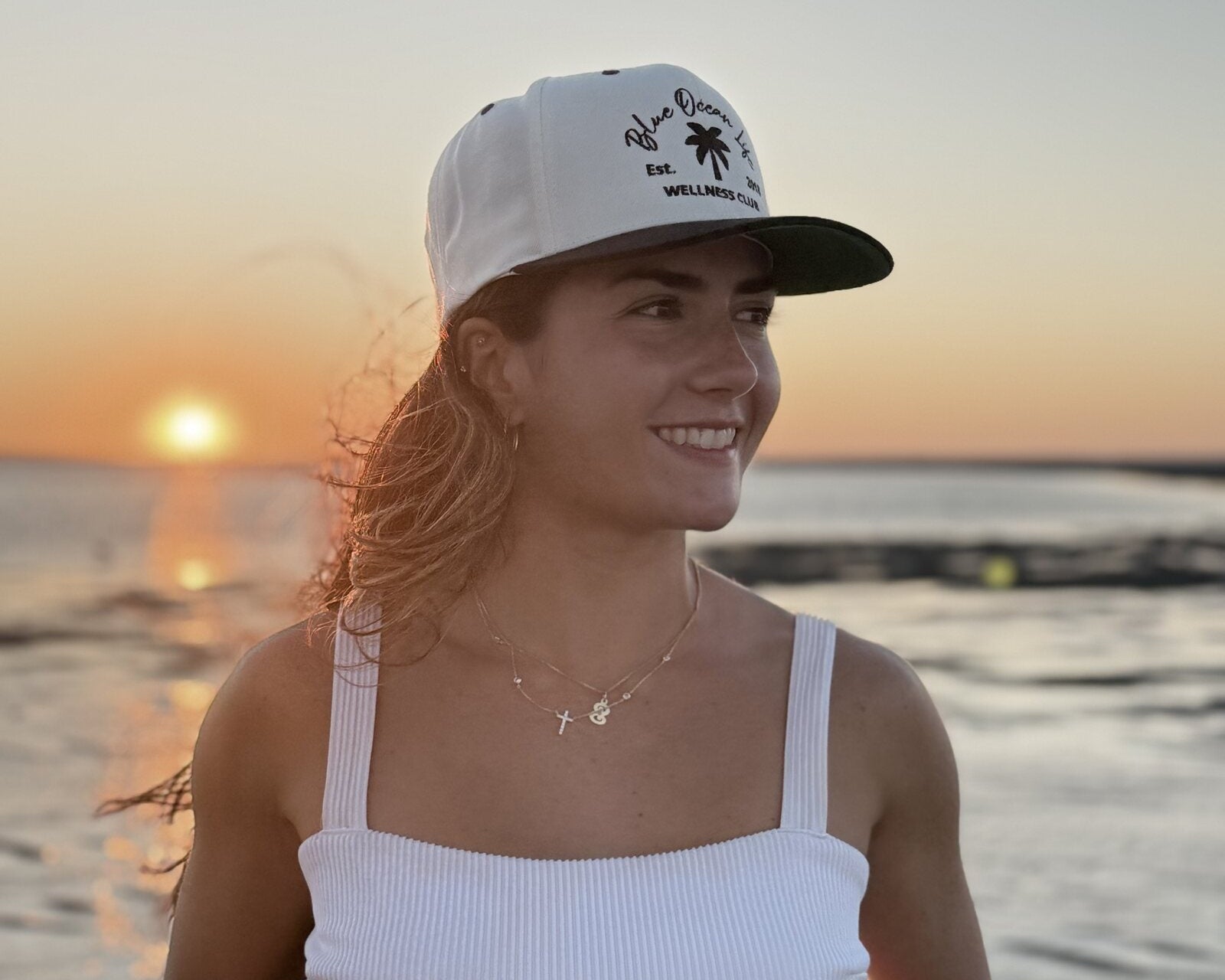 Close-up right-side view of the Blue Ocean Life Wellness Club Snapback Hat at sunset