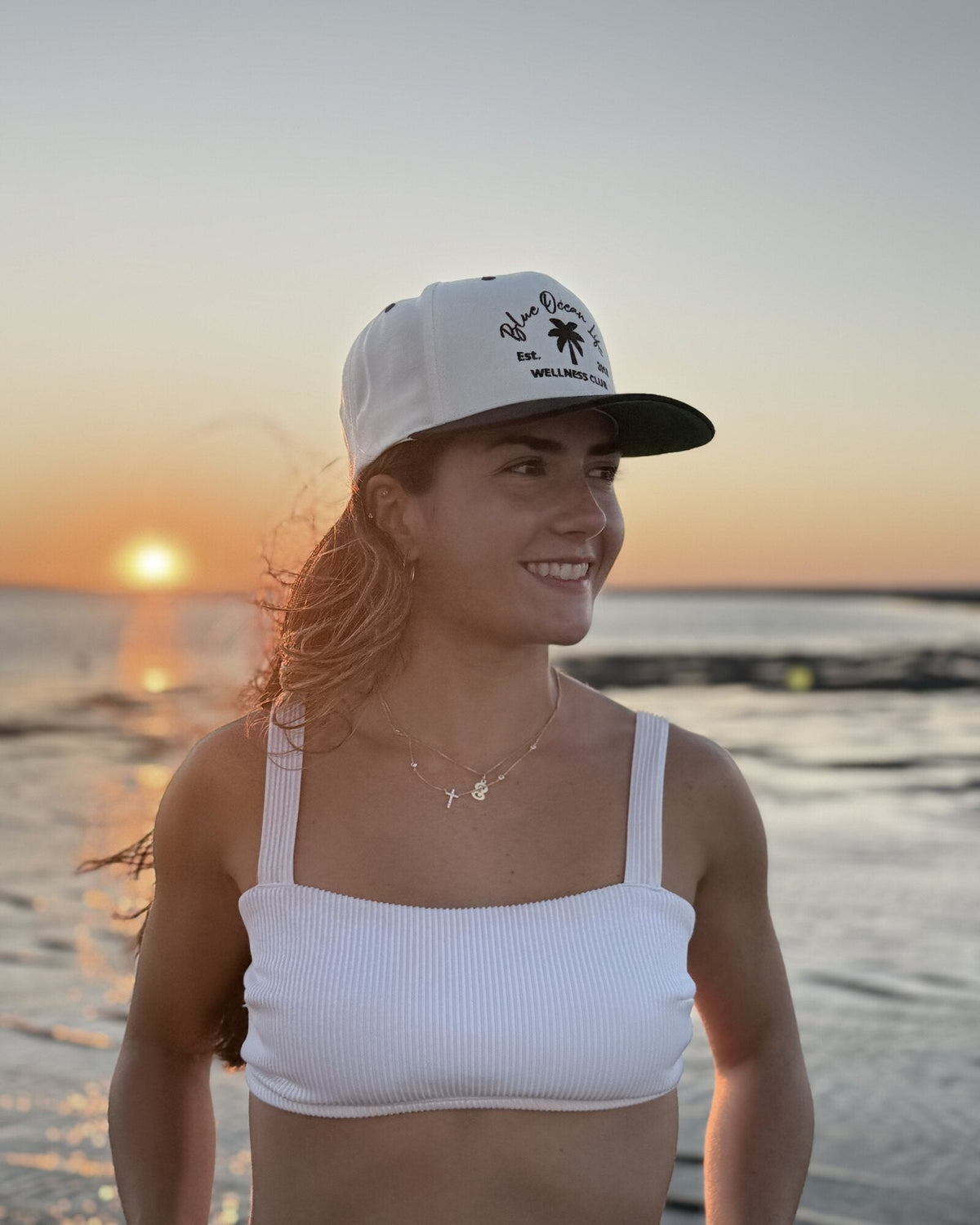 Close-up right-side view of the Blue Ocean Life Wellness Club Snapback Hat at sunset
