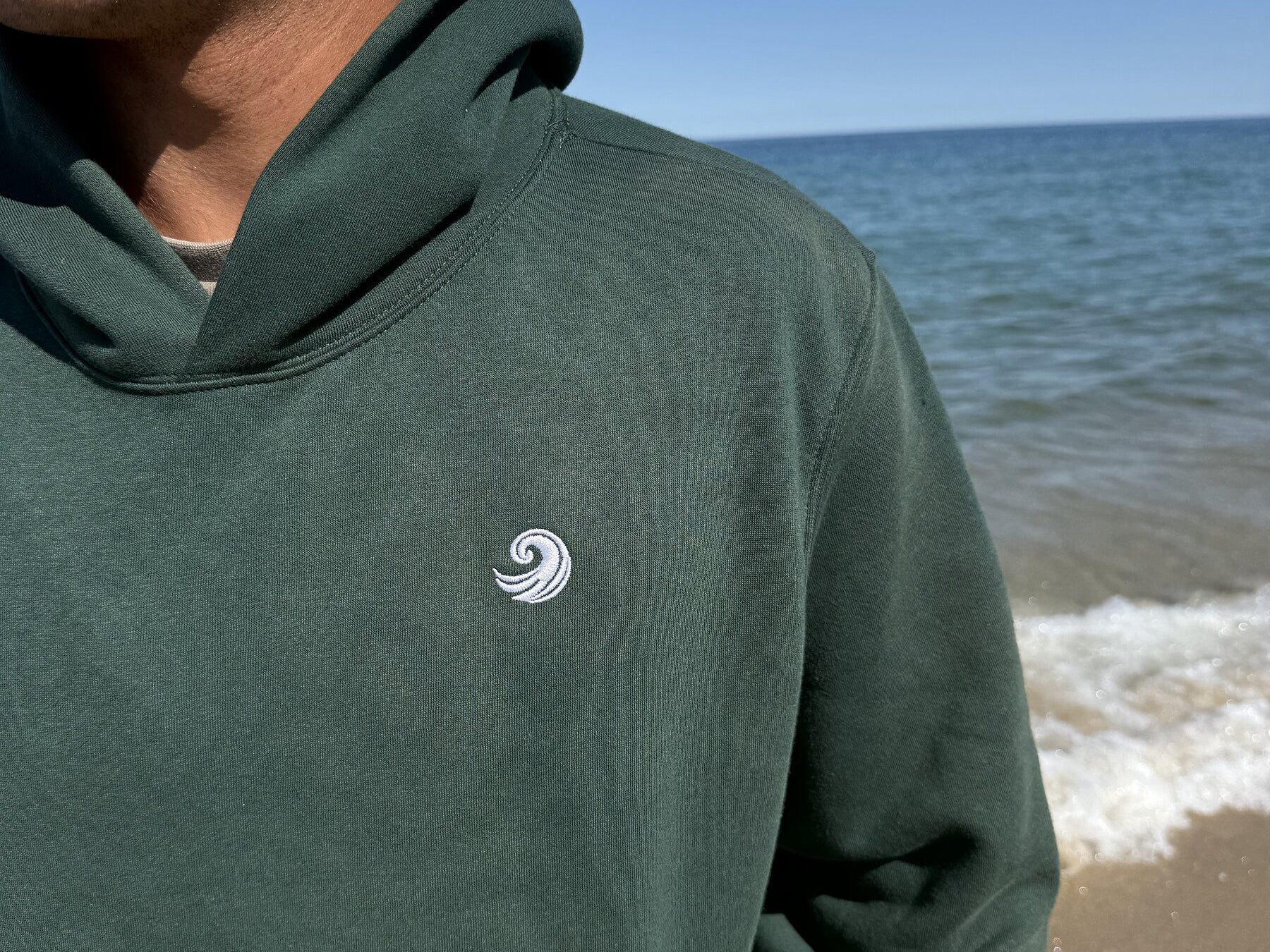Healing Wave embroidery detail on forest green hoodie