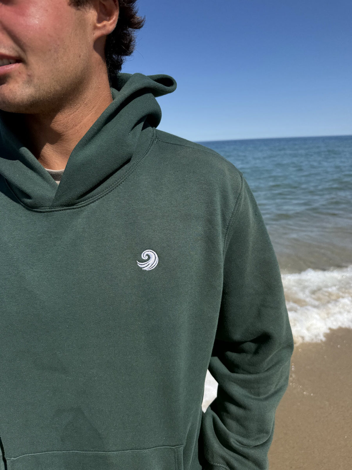 Healing Wave embroidery detail on forest green hoodie